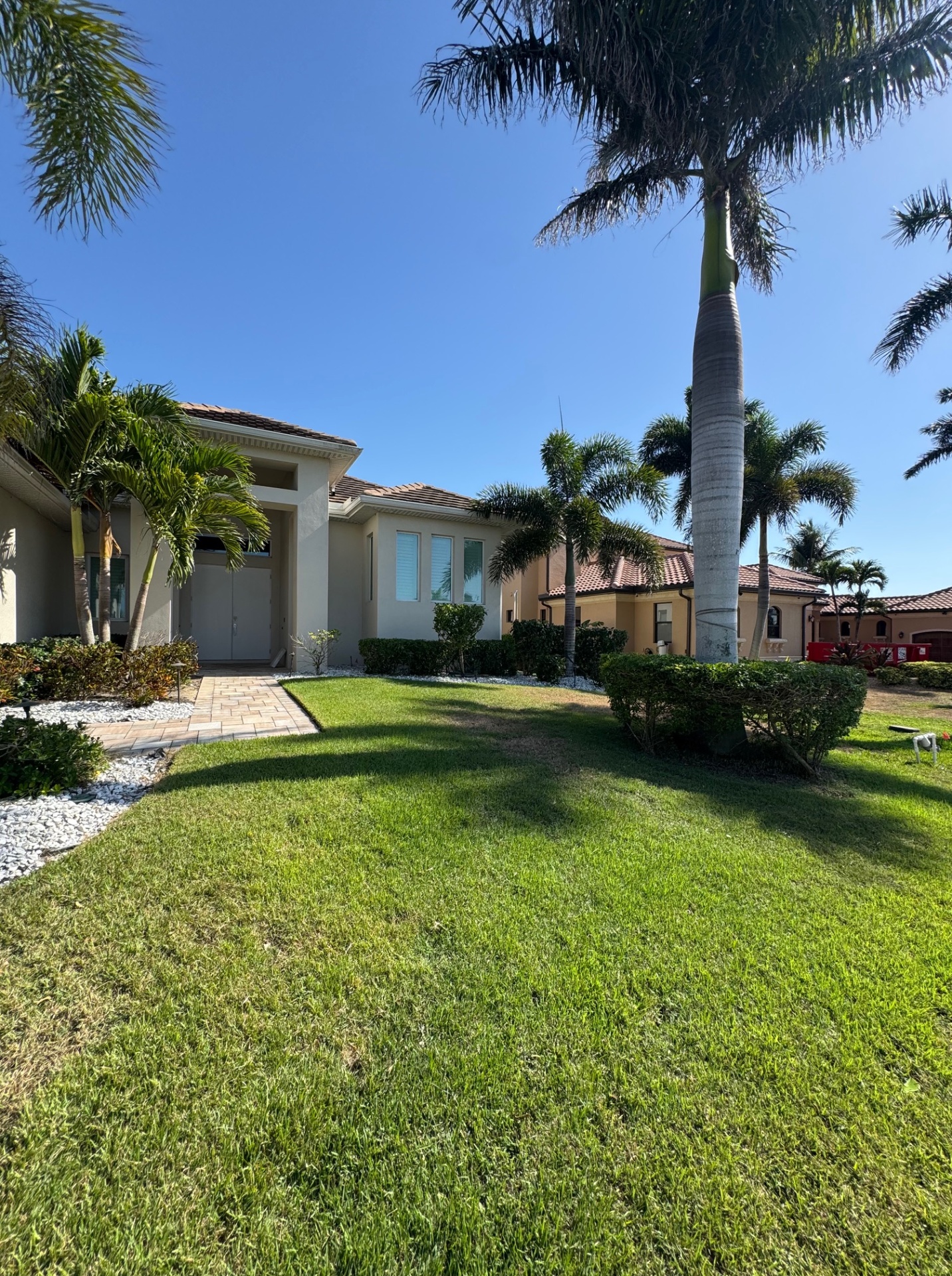 Beautifully landscaped front yard showcasing green grass and well-maintained shrubs, acheived by All In One Property Care's Lawn service in Cape Coral