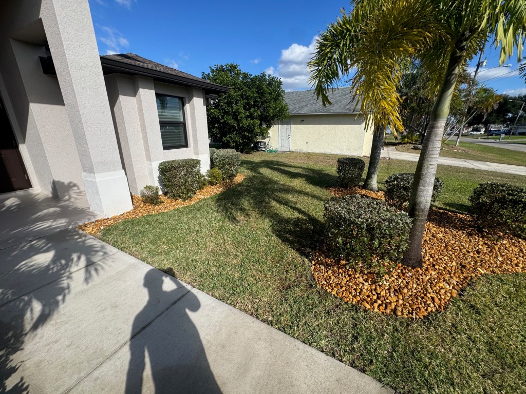 A beautifully landscaped front yard featuring carefully edged shrubbery and decorative mulch, enhancing the home's curb appeal.